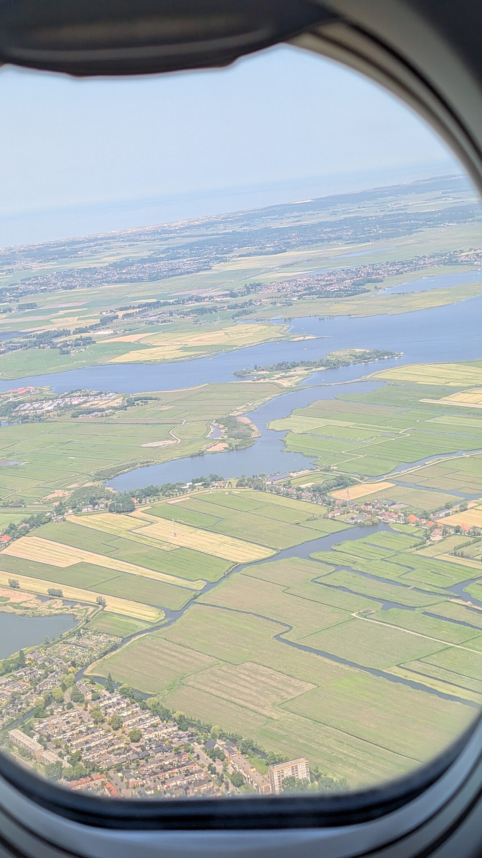 Aerial mosaic of fields, forest, and water — the kind of landscape Ekoya works across.